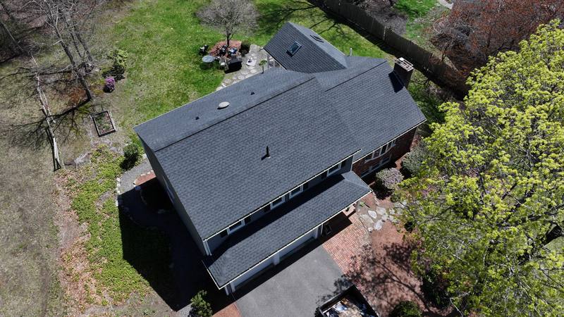 Dark shingle roof on a colonial with an attached garage