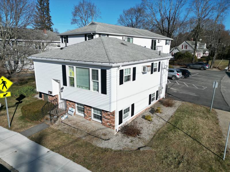 White two-family home with vinyl siding, gutters and a hip roof